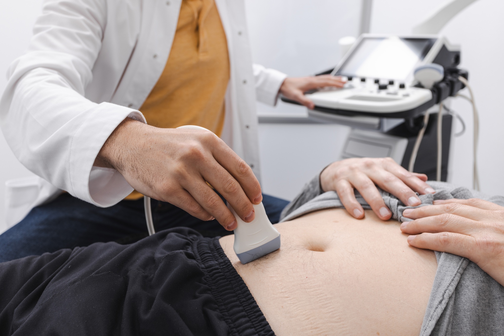 Abdominal ultrasound with ultrasound machine for male patient, close-up