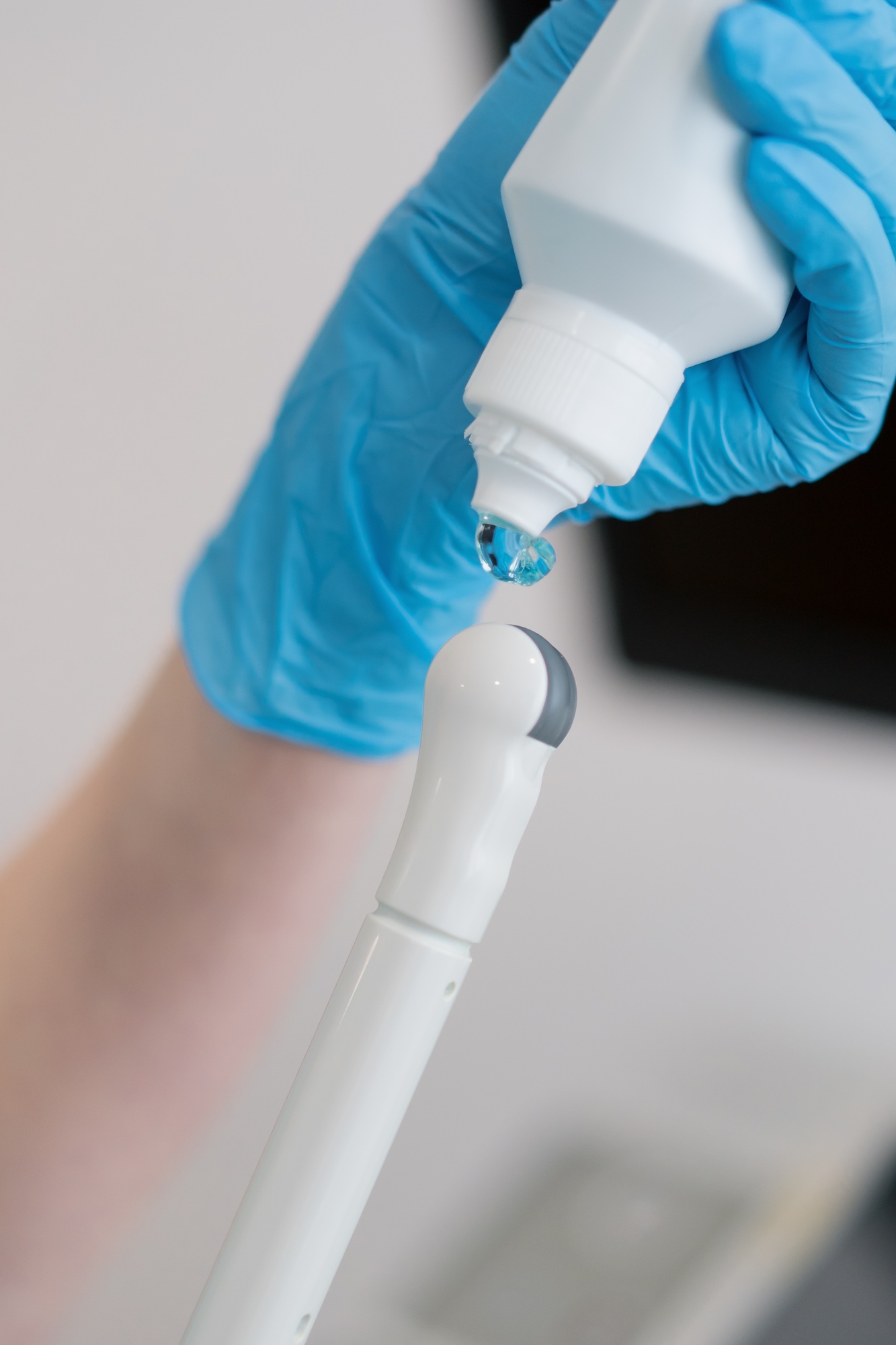Gynecologist applying gel on transvaginal ultrasound to diagnose patient in clinic medicine