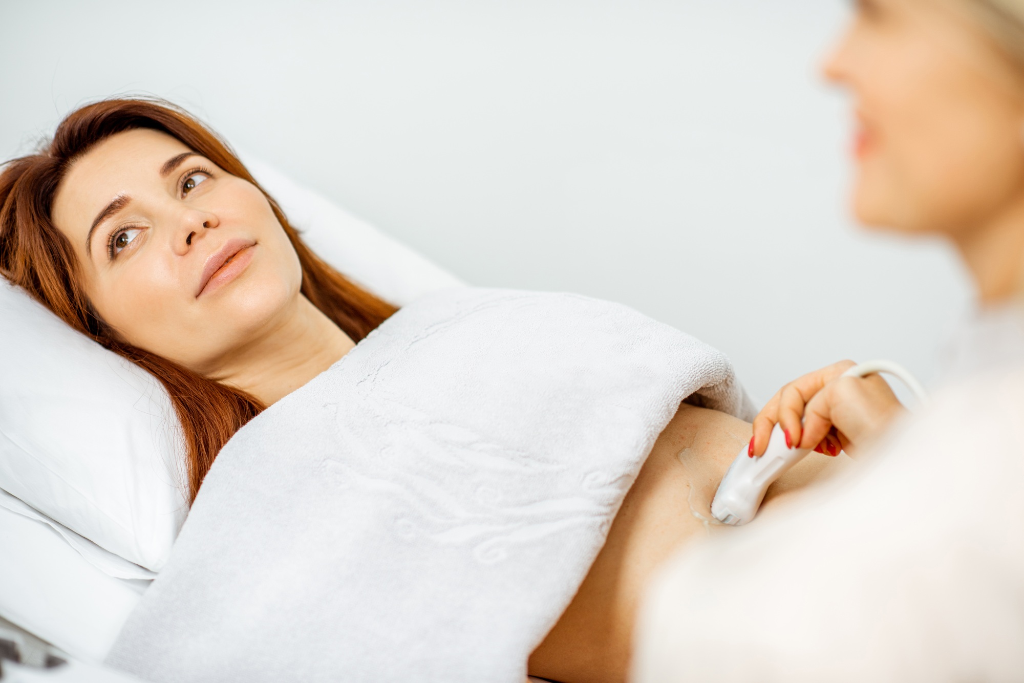 Woman examining her abdomen with ultrasound